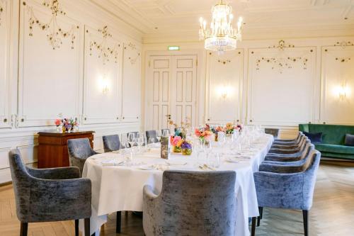 a long table in a room with chairs and a chandelier at Louis C Jacob, Hamburg, Autograph Collection in Hamburg