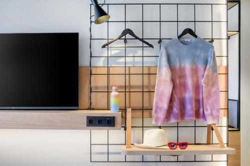 a shirt and sunglasses on a shelf next to a tv at Moxy Verona in Verona