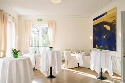 a dining room with white tables and white chairs at Louis C Jacob, Hamburg, Autograph Collection in Hamburg