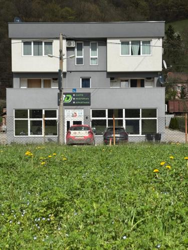 a building with two cars parked in front of it at APARTMAN Visoko in Visoko