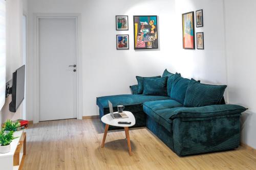 a living room with a blue couch and a table at Red apple in Kastoria