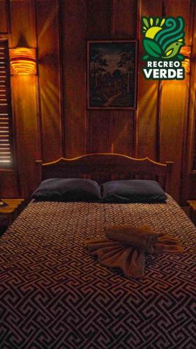 a bedroom with a bed with a sign on the wall at Recreo Verde Hot Springs & Spa in Marsella