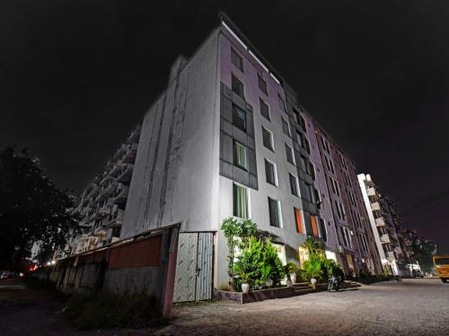 a tall white building with colorful windows at night at Townhouse Classio Suites in Shirdi