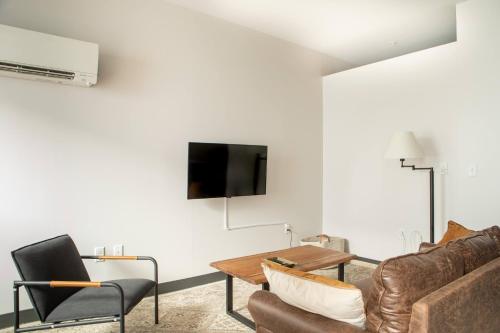 a living room with a couch and a tv on a wall at Deer District Studio Apt - One Block from Fiserv and Baird in Milwaukee