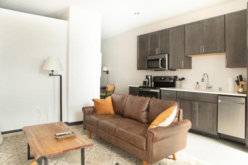 a living room with a couch and a kitchen at Deer District Studio Apt - One Block from Fiserv and Baird in Milwaukee
