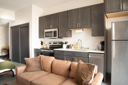 a living room with a couch in a kitchen at Deer District Studio Apt - One Block from Fiserv & Baird in Milwaukee