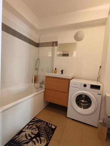 La salle de bains est pourvue d'un lave-linge et d'une baignoire. dans l'établissement Charmant Studio Savigny-Le-Temple Nandy, à Savigny-le-Temple