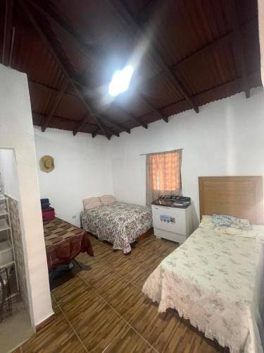 a room with two beds and a table in it at Rancho La Loma in Higuey