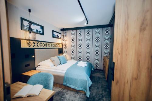 a bedroom with a bed and a table and a chair at Dom Wypoczynkowy u Czerników in Białka Tatrzanska