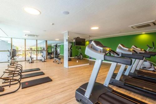 a gym with exercise equipment and green walls at Beach Class Convention - Flats em Boa Viagem por Yolo in Recife