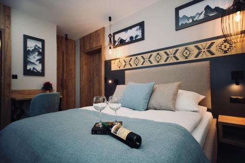 a hotel room with a bed with a bottle and two glasses at Dom Wypoczynkowy u Czerników in Białka Tatrzanska