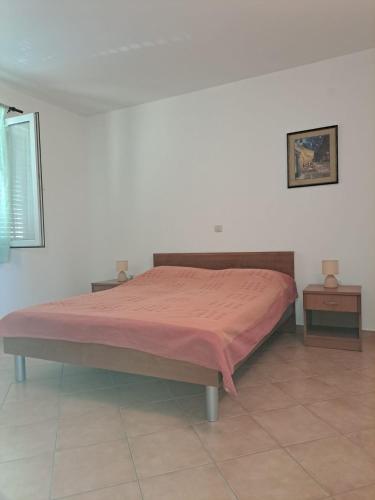 a bedroom with a bed with a pink blanket at Apartment Frodo in Makarska
