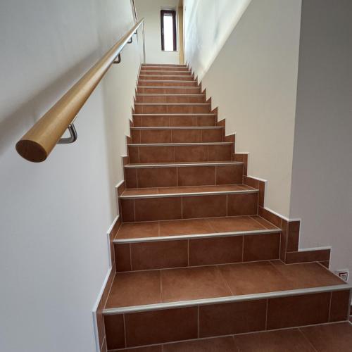 a staircase with brown tile and a wooden rail at Vinařský dům V Zahradě in Pasohlávky