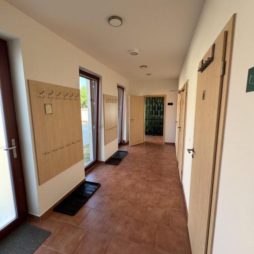a hallway of an office with doors and tile floors at Vinařský dům V Zahradě in Pasohlávky
