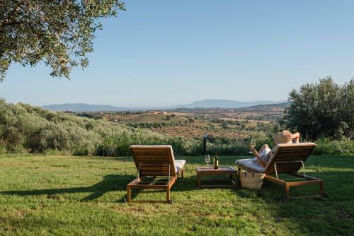 a woman sitting in a chair in the grass at Il Giardino di Elena in Montiano