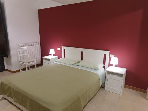 a bedroom with a large bed with a red wall at Terrazze Bella Epoque in Acireale