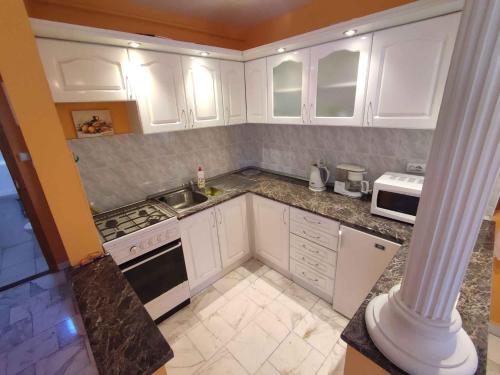 a kitchen with white cabinets and a stove top oven at Apartment in Zamardi - Balaton 33875 in Zamárdi