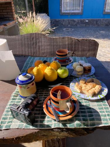a table with a plate of fruit and a cup of coffee at Cabañas Pukara in Cafayate