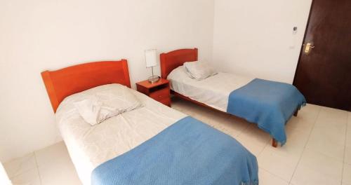 a bedroom with two beds and a night stand with a bed sidx sidx sidx sidx at Quinta Azul in Loulé