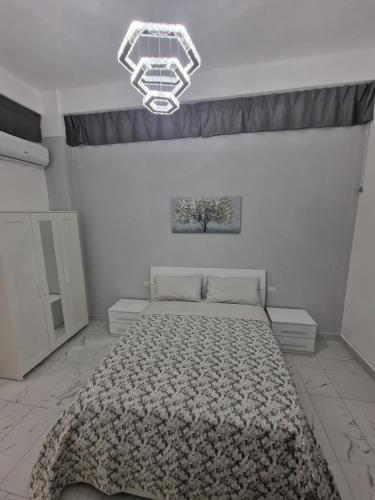 a bedroom with a bed and a chandelier at Marilissa Home in Bari