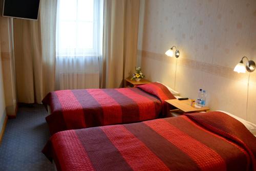 a hotel room with two beds and a window at Demians in Saldus