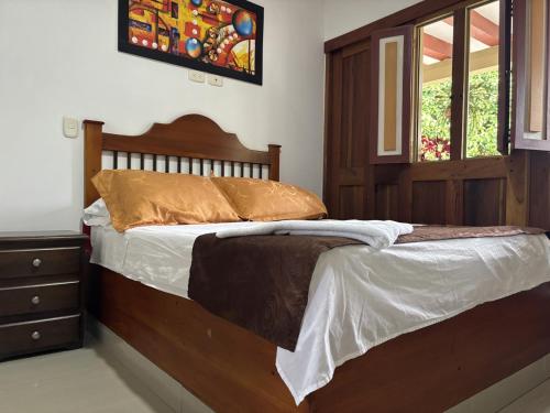 a bed with a wooden headboard in a bedroom at Hotel Balcon Tamesino in Támesis