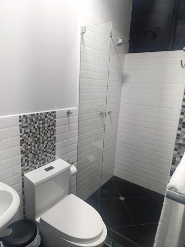 a white bathroom with a toilet and a sink at Morro Calzada in Moyobamba