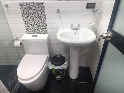 a bathroom with a white toilet and a sink at Morro Calzada in Moyobamba