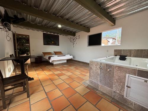 a large room with a tub and a bed at Hotel Balcon Tamesino in Támesis