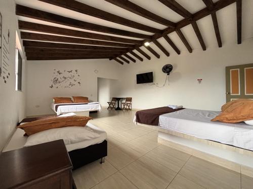 a large room with two beds and a television at Hotel Balcon Tamesino in Támesis