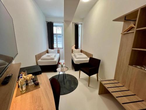 a room with two sinks and a living room with a couch at Adlzreiter City Pension in Munich