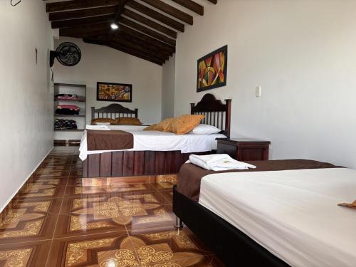 a bedroom with three beds in a room at Hotel Balcon Tamesino in Támesis