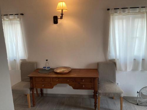 a room with a wooden table with two chairs and a lamp at Yoga Farm in Tavira