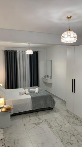 a bedroom with a large bed and two chandeliers at Rozafa Guest Room Center in Shkodër