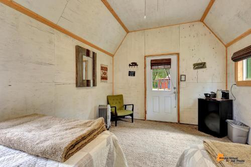 a bedroom with a bed and a chair in a room at DFA Cabin Rentals in Talkeetna