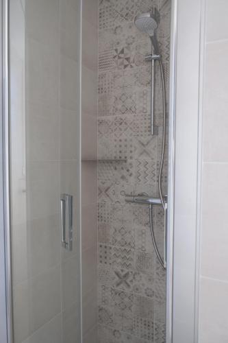 une douche avec une porte en verre dans une salle de bain dans l'établissement Côte Ouest, à Lanvénec