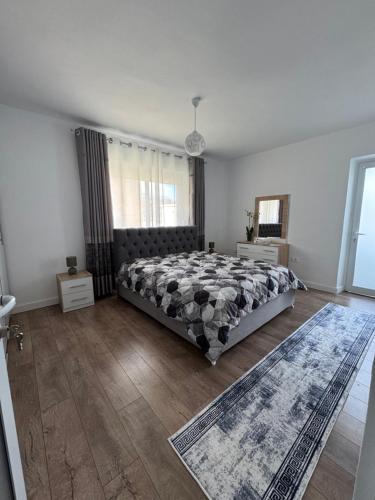 a bedroom with a bed and a large window at Joanna's Guest House- New renovation in Tepelenë