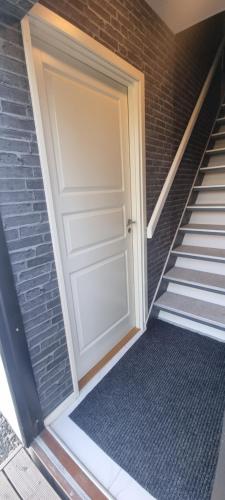 a door on a brick building with a staircase at Cozy apartment Rose in Fjälkinge