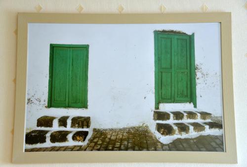 a painting of two green windows on a white wall at Demians in Saldus
