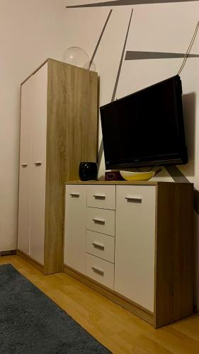 a tv on top of a dresser with a cabinet at Kawalerka Oaza Mnicha in Gdańsk