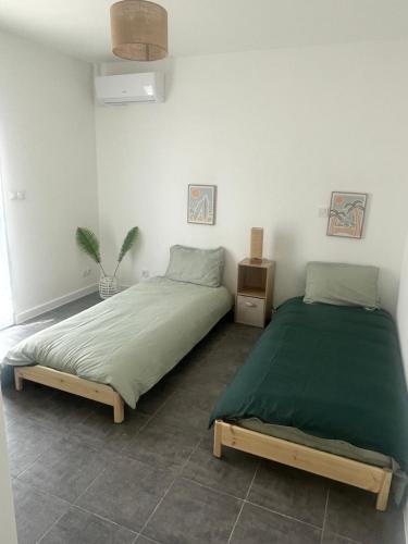 a bedroom with two beds in a room at Au bonheur du Sud in Olonzac