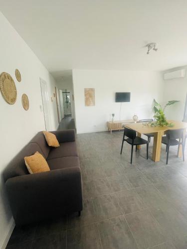 a living room with a couch and a table at Au bonheur du Sud in Olonzac