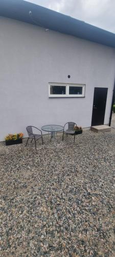 two chairs and a table in front of a building at Cozy apartment Rose in Fjälkinge