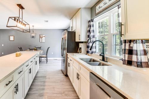 Una cocina con gabinetes blancos y un fregadero y una ventana. en Hike, Fish and Explore Retreat in Silver Springs!, en Silver Springs