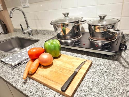 a cutting board with vegetables on a kitchen counter at Vineyard Olive Inn - cercanía salón Terra Oliva, bodega Casa Vigil, La Rural, Trapiche, Florio y muchas máss in Maipú