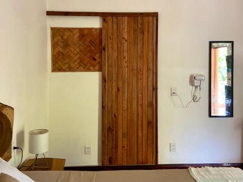 a bedroom with a wooden door and a phone on the wall at Maracuya Suites Zipolite in Zipolite