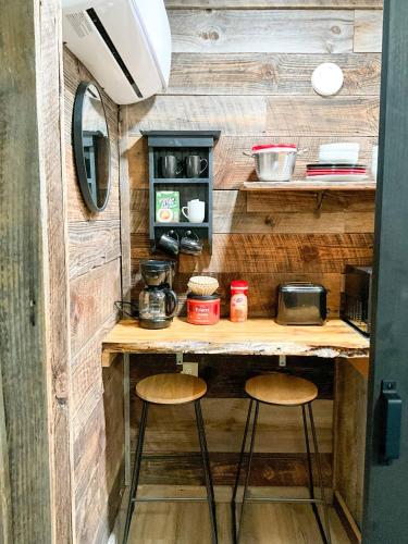 a kitchen with two stools at a counter in a tiny house at "Moon Glow" - Cozy Climber Retreat in Muir Valley in Rogers