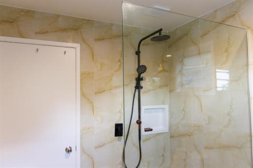 a shower with a shower head in a bathroom at Muri Ocean View Villas in Ngatangiia