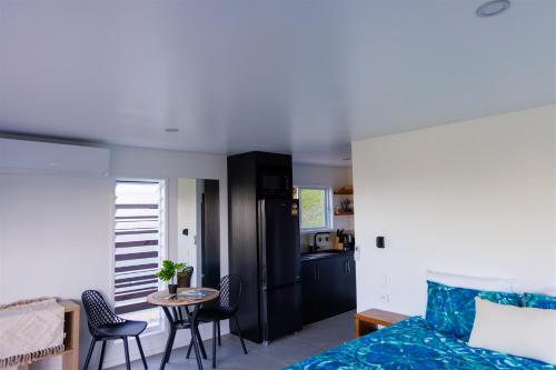 a living room with a bed and a table and a kitchen at Muri Ocean View Villas in Ngatangiia