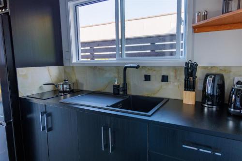 a kitchen with a sink and a window at Muri Ocean View Villas in Ngatangiia